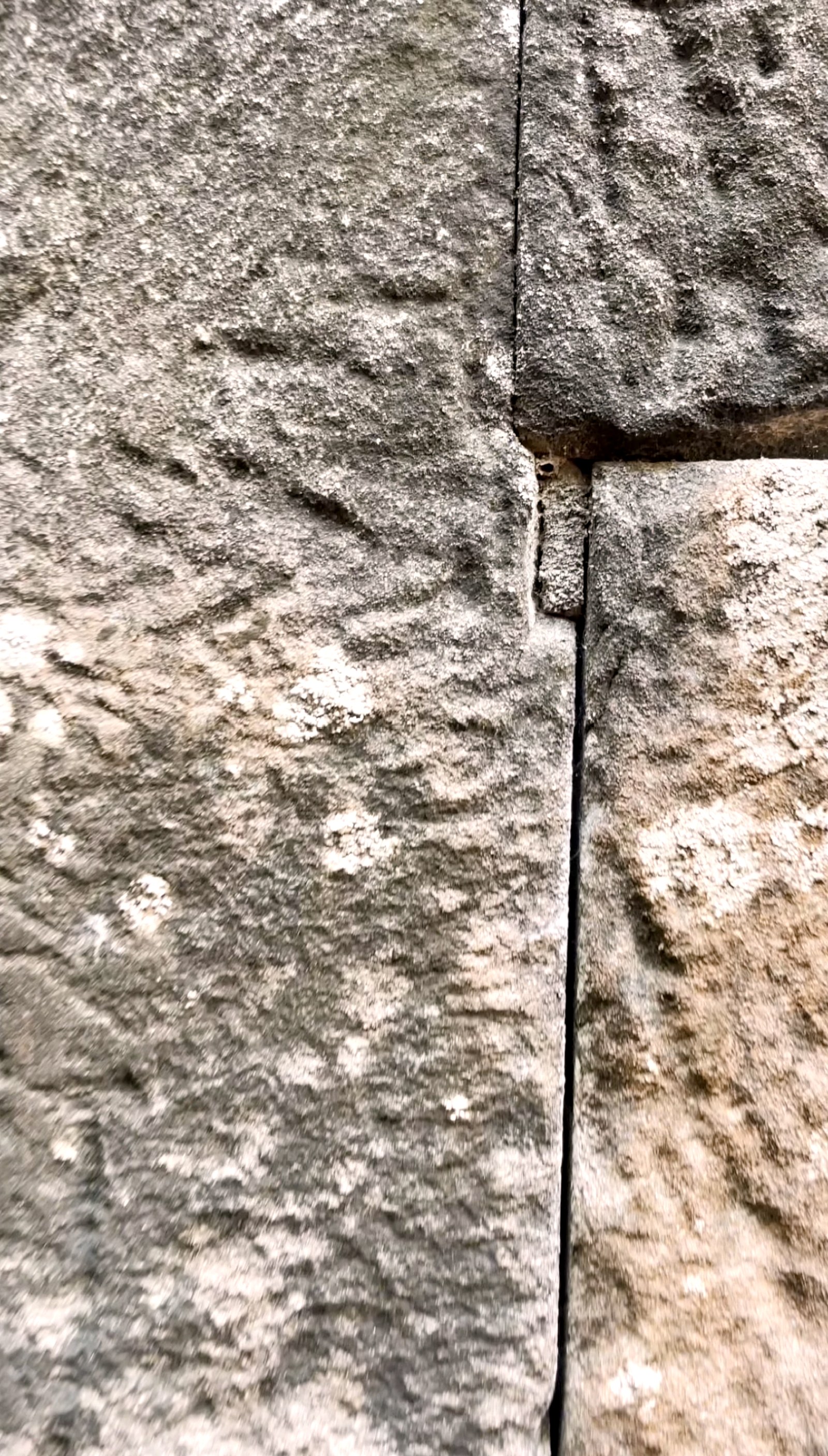 Phnom Bok mini megalith: a fingertip-sized inset stone where two polygonal blocks with bent corners meet.