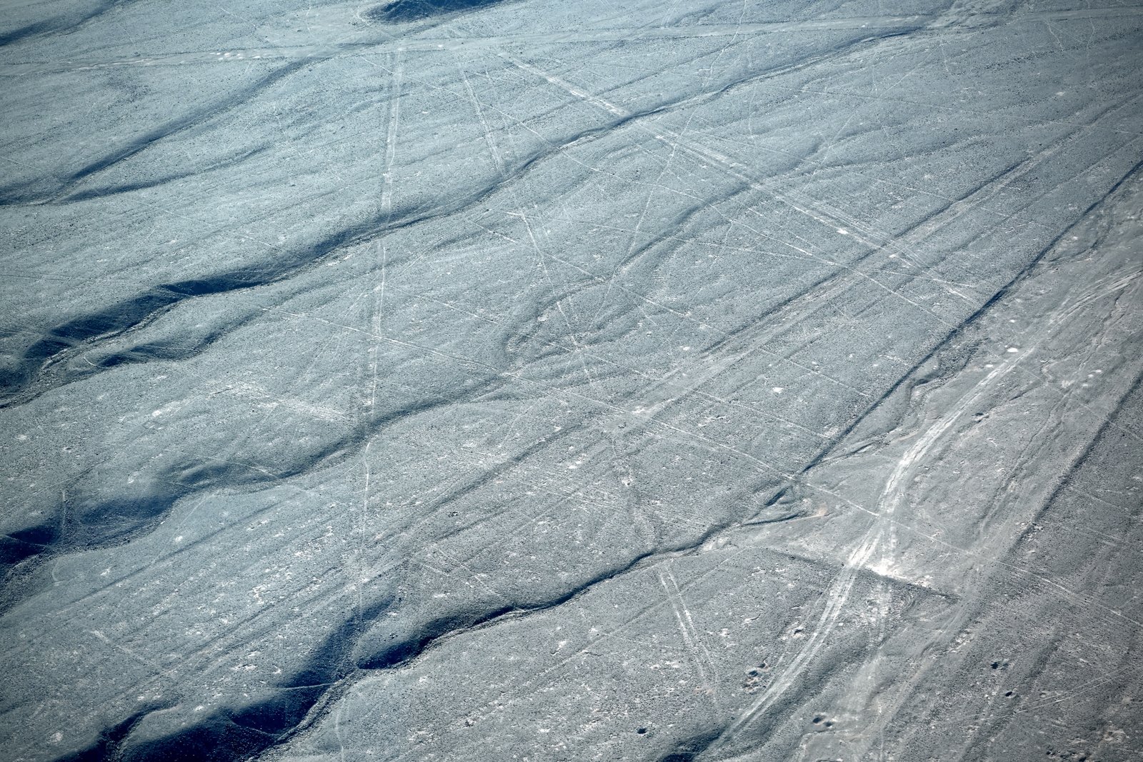 Dead-straight Nazca lines running for kilometers across the desert, intersecting.